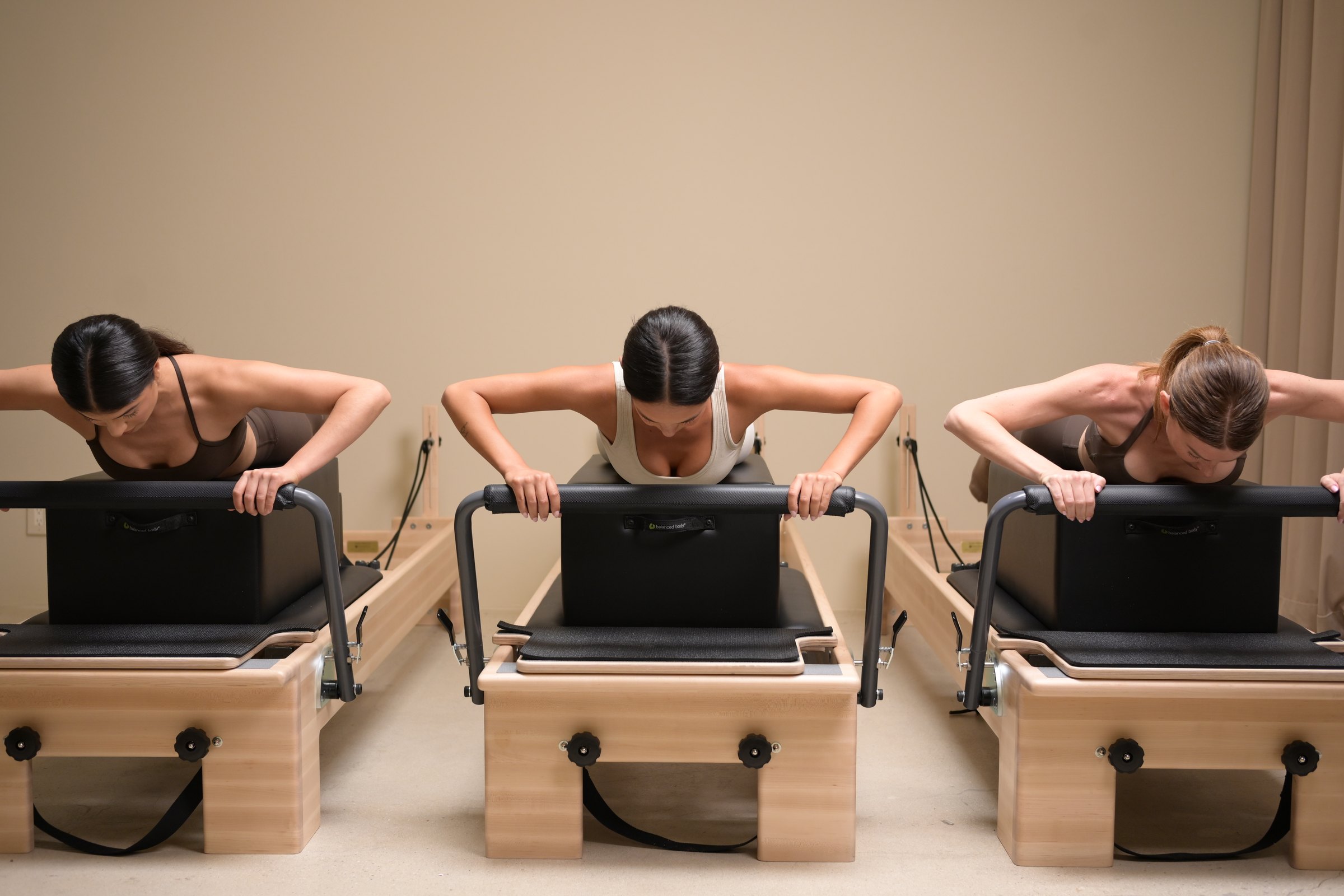 Three students leaning over the reformer boxes